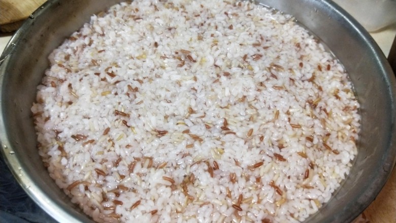 五谷杂粮木桶饭,第一个“蒸”好以后的杂粮饭是夹生的,把夹生的杂粮饭倒入另外一个容器(最好是带盖子的)中。