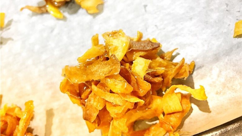 🍠日式番薯脆酥糖🍠,糖浆熬好后,将番薯片全部倒入锅中开始翻拌。尽量拌匀。虽然这不太容易。
整形阶段,趁热,将酥糖整成团装放在烤盘上晾凉。你可以配合勺子🥄来操作这一步。因为确实比较烫。