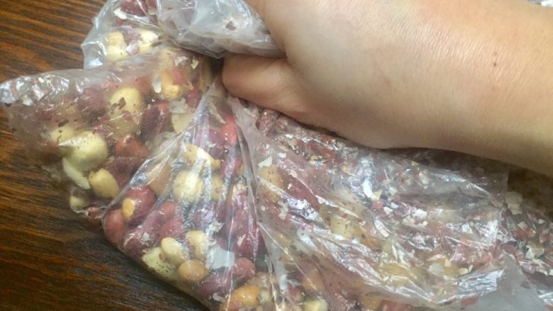 曼妙生花~~牛轧糖,取保鲜袋将花生放入,如图这样回复搓,去皮