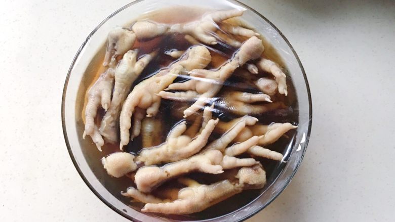虾油卤鸡爪,等卤水和鸡爪全部冷却后,把鸡爪浸泡在卤水里,包上保鲜膜放入冰箱冷藏24小时就可享用了