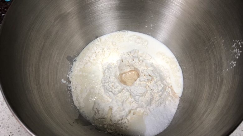 红糖花生“蘑菇”包,面粉中间挖一小孔倒入活性干酵母,细砂糖倒在一边,倒入牛奶