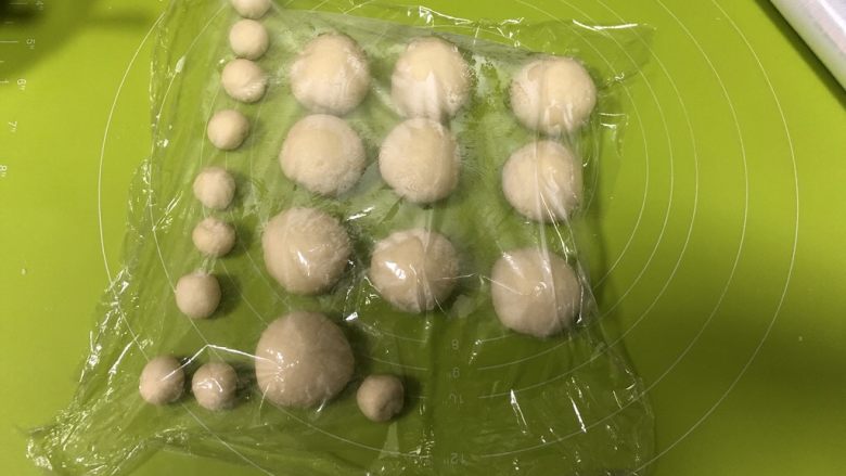 红糖花生“蘑菇”包,取出面团按压排气，分为10个28g/个的稍微大点的面团，10个5g/个的小面团，盖上保鲜膜醒发10分钟