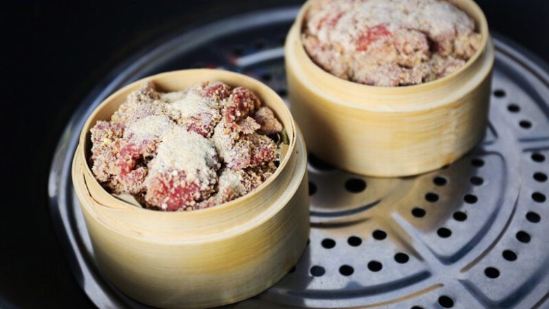 粉蒸牛肉,将剩余的米粉盖在牛肉上,笼屉上蒸锅;