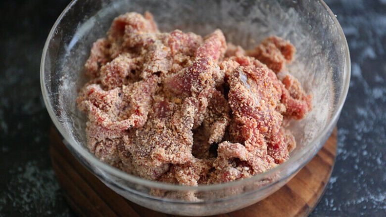 粉蒸牛肉,加入打好的米粉,用手充分抓拌均匀,将米粉裹满牛肉片;
