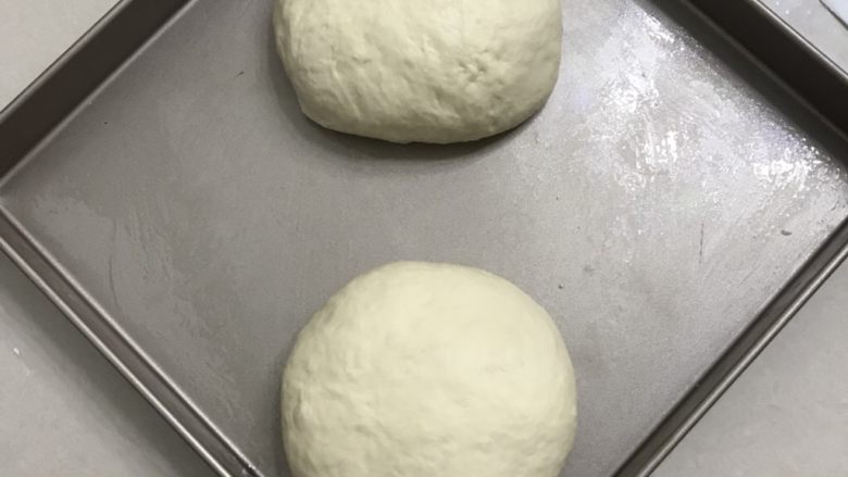 肉松面包卷,9 倒出来拍打面团排气,分成二份滚圆,放入金盘中,盖上保鲜膜放进发酵箱,温度还是27度,松弛20分钟。