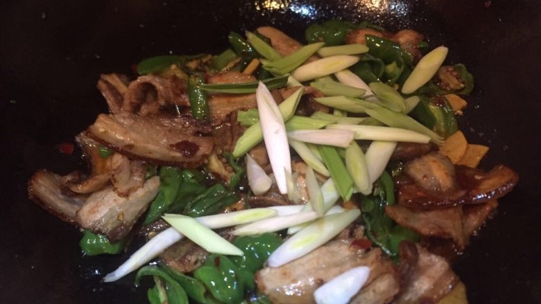 家常菜，回锅肉,倒入葱段翻炒均匀
