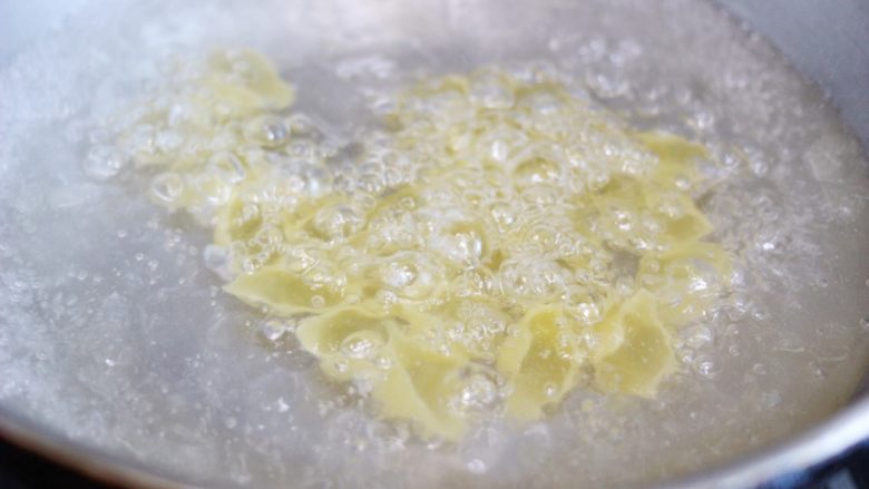意大利芹菜甜虾芝士贝壳面,锅中放入橄榄油和盐开始煮贝壳面。煮熟后捞出沥干水份,再淋上橄榄油拌匀,防止粘黏