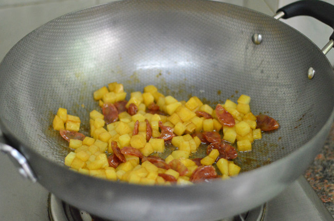 土豆腊肠焖饭,拌炒至土豆变色呈透明状后,调入<a style='color:red;display:inline-block;' href='/shicai/ 788'>生抽</a>和少许盐调味