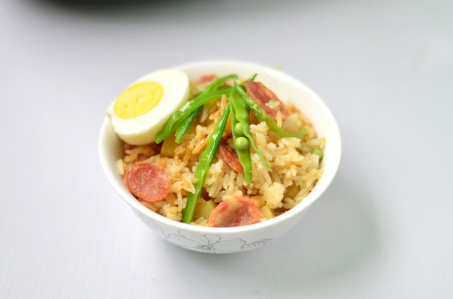 土豆腊肠焖饭,盛出,摆上鸡蛋即可