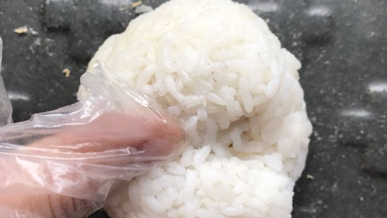 咸蛋黄肉松饭团-泰迪版,把饭团放平盘上,双手拇指轻轻按出双眼凹位(我的另一手要拿机);