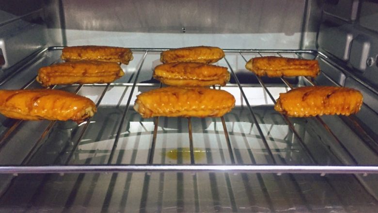 美味烤鸡翅,在烤网上先刷一层油,然后将腌好的鸡翅摆放在烤网上,将烤网放入烤箱中层,上下火210度烤10分钟。(烤网下面放一个烤盘,烤盘里最好放上水,这样容易清洗哦)