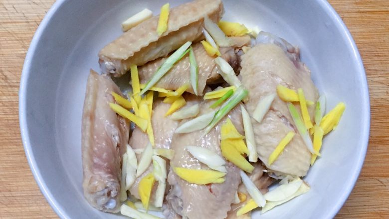 美味烤鸡翅,将鸡翅控干水分放入大碗中,加入葱姜蒜。