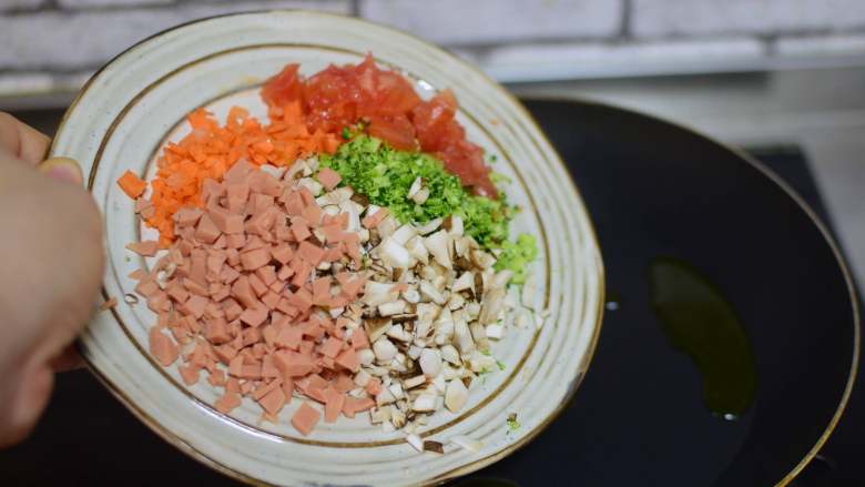 蛋里藏娇,锅中油热,加菜末、火腿肠末炒两分钟