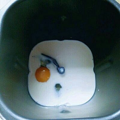 椰蓉吐司面包,将牛奶倒入面包桶,再加入鸡蛋。