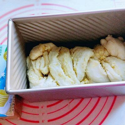 椰蓉吐司面包,编好收口朝下,放入模具中,入烤箱进行二次发酵