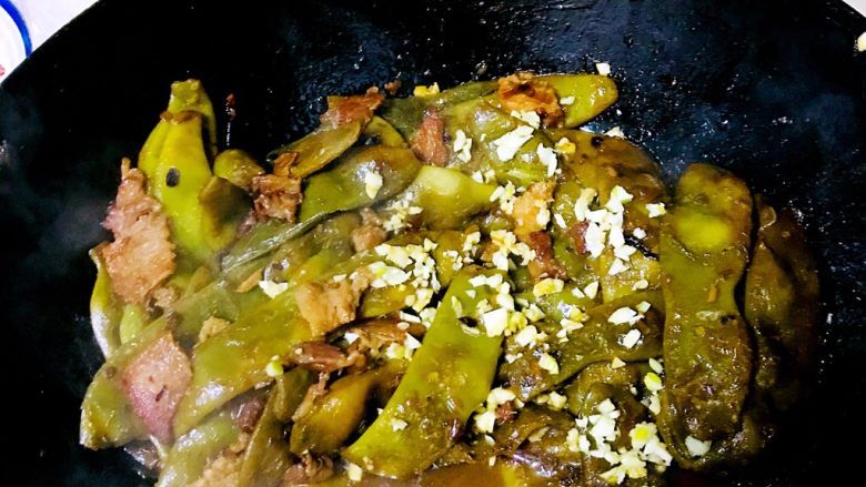 猫厨物语-蒜香油豆角,关火。把蒜蓉倒进去用豆角的热量翻炒几下,你会闻到特别香的蒜香味。