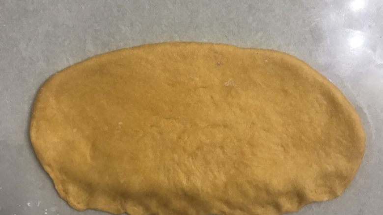 南瓜蜂蜜排包,翻面再擀一下,靠近自己的一面用手指压扁压薄,便于捏紧接口。