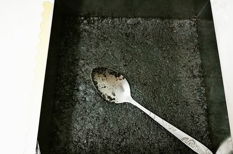 简单易学—8寸芒果慕斯免烤蛋糕,把饼干碎倒入模具,借助勺子来回不断压实,尽量抹平,这步很重要,多压一会哦。放冷藏备用。