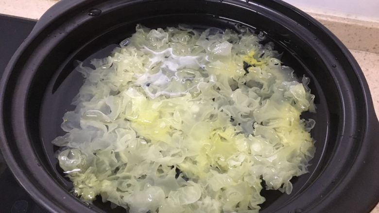 糯糯的银耳红枣汤,把泡好的银耳处理一下,去掉底部黄色的部分,然后剪刀剪成小朵,放入锅里,加水漫过。我用的是塔吉锅。