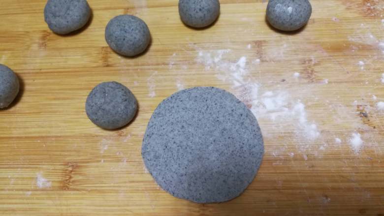 圆嘟嘟小刺猬—豆沙包,黑色面团分成11份,留一份后面做眼睛。另外10个擀成圆片。