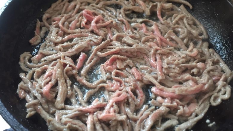 泡椒牛肉丝,倒入牛肉丝炒散,变色倒入盘中。