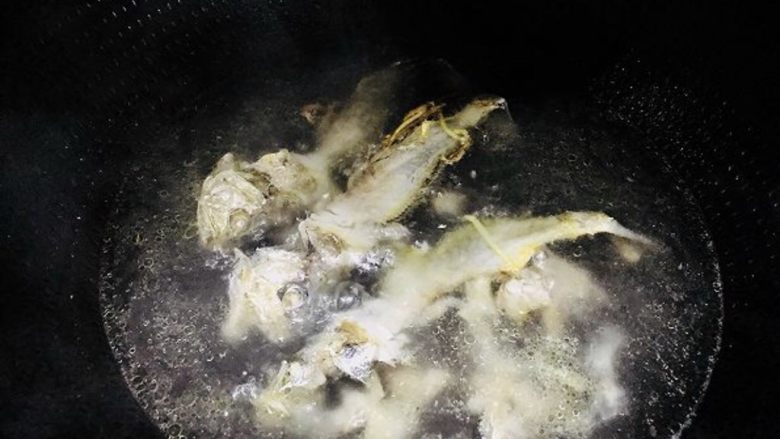 咸菜黄鱼面,另起一口锅,放一碗水烧开,倒进煎好的鱼骨,熬制十分钟(第四步和第五步可以同时进行)