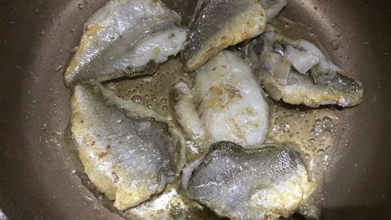 咸菜黄鱼面,炖鱼汤时,可以煎鱼肉哦:把安置好的鱼肉放进刚才煎鱼骨的油锅里,煎到两面金黄