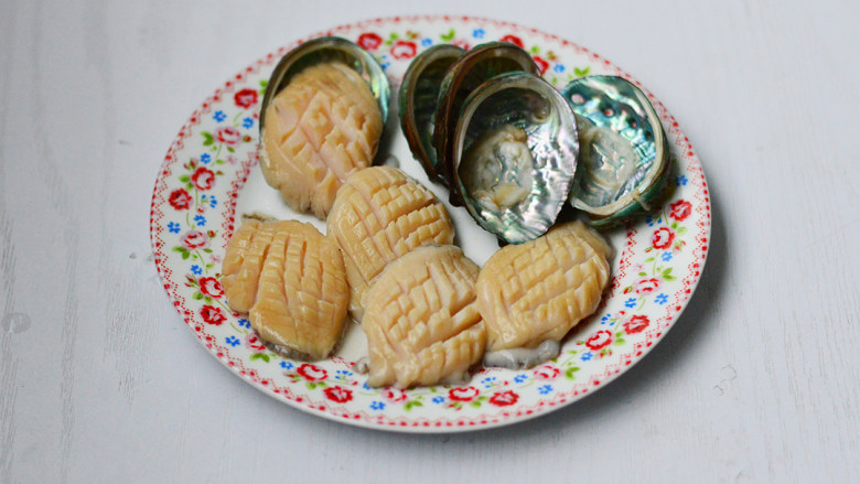 蒜蓉粉丝蒸鲍鱼,用小刀或勺子柄将鲍鱼肉挖出,去除内脏,冲洗干净,在鲍鱼肉上划一些花刀,鲍鱼壳也同样刷洗干净备用