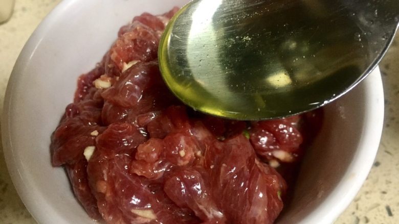 绝代双椒牛肉丝,盐,淀粉和牛肉搅拌和再放入一勺玉米油