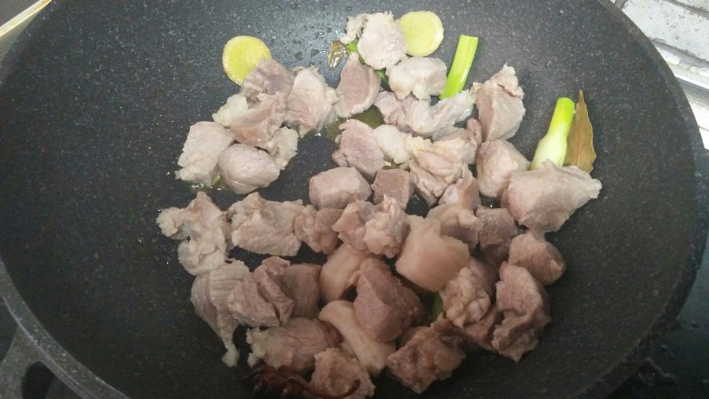 红烧羊肉,加羊肉、葱姜,炒两分钟