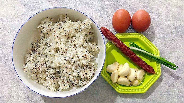 炒饭秀~金蒜飘香の腊肠黄金鸡蛋炒藜麦饭,首先我们准备好所有食材,藜麦米饭是前一晚煮好的,煮的时候把藜麦和大米一起放入电饭煲,和平时煮饭一样的