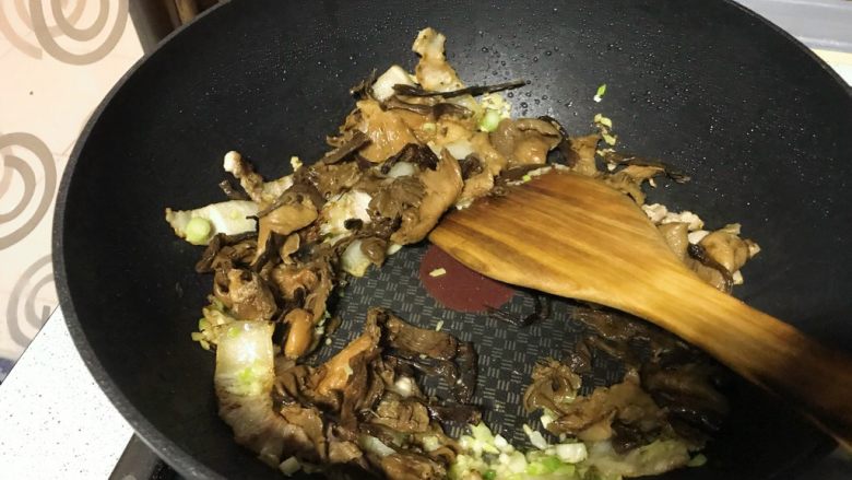 榛蘑炒辣椒,再倒入蘑菇,淋一汤匙酱青,翻炒。