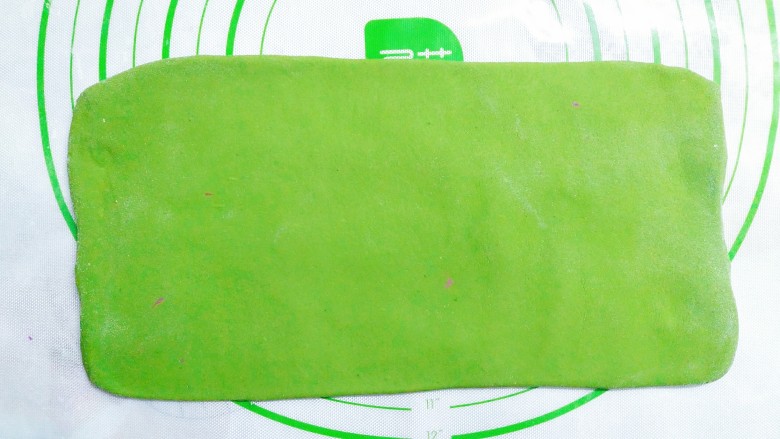 花样蒸饺系列(1),把绿色面团用擀面杖擀成长方形的面皮!在上面刷点水!
