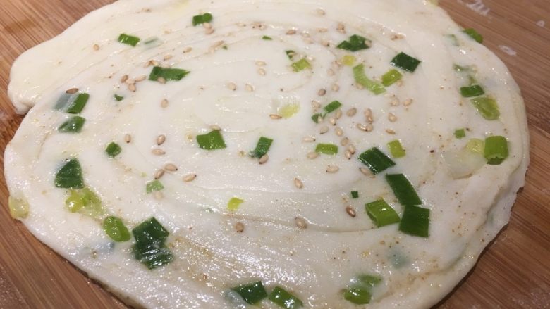 芝麻葱香饼,撒少许芝麻,用擀面杖擀成圆形