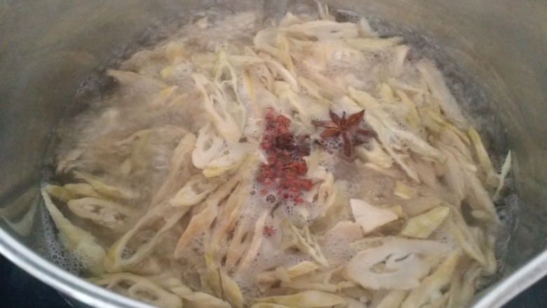 家常菜~笋干炒腊肠,锅中烧开水,放<a style='color:red;display:inline-block;' href='/shicai/ 695'>八角</a>,红椒和笋干片下去,煮10-15分钟,焖一会捞出沥干水备用。