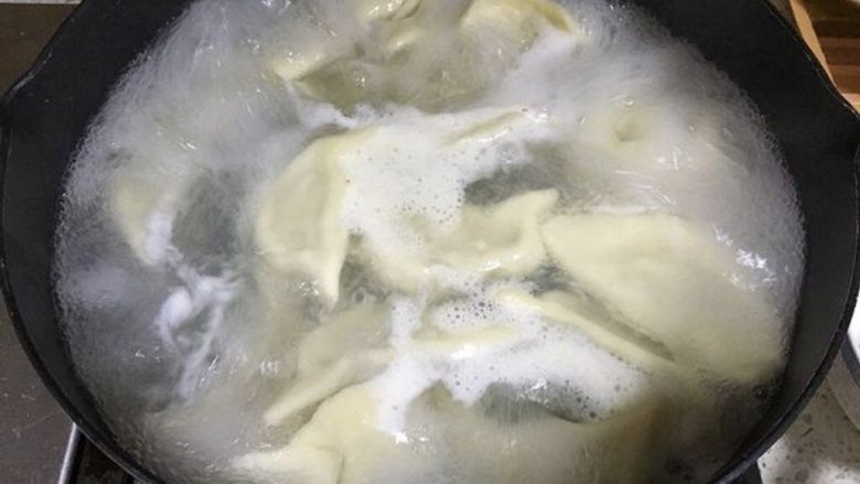 手工韭菜鸡蛋饺子,坐一锅热水,水微沸腾时倒入饺子,第一次水煮沸腾后加入适量清水,等待第二次沸腾,然后再加一次凉水继续煮,这次盖上锅盖,主要要守着锅,以免水沸腾扑出来。