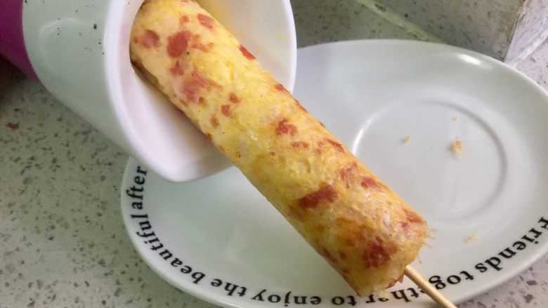 快手早餐—火腿鸡蛋米饭肠,烤好后米饭肠会自动升起,把蛋肠机横过来,把米饭肠轻轻倒入盘中,不要把肠折断。