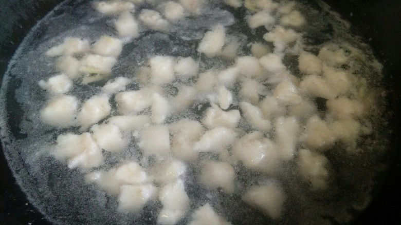 番茄龙利鱼,腌制好的龙利鱼焯水,下锅后要用筷子把鱼肉划散,只要鱼肉变白就捞出来