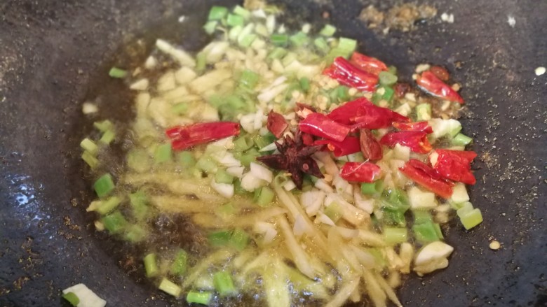 红烧鳕鱼,鱼块全部炸好后,锅内留少许油,放入葱,姜,蒜,朵椒,八角炒香。