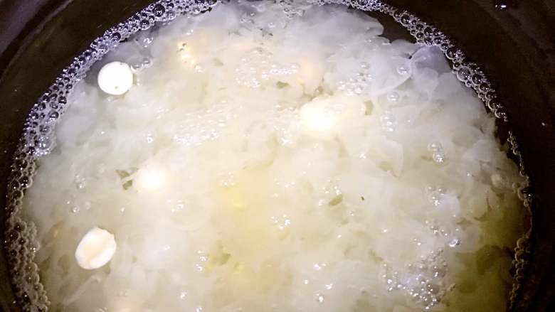 银耳莲子汤,等高压锅的气全部释放完以后,将银耳汤倒入砂锅中,同时放入莲子,再倒入适量的开水,先大火烧开,然后转小火慢慢炖40分钟左右。(此时银耳已经比较懦、比较粘稠,建议时不时搅拌一下,以防粘锅)