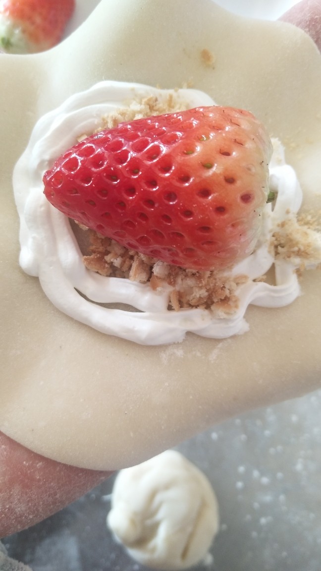 雪媚娘,7.冷却后的皮用擀面杖敢开,挤上淡奶油,放上饼干碎,喜欢的水果,然后再包好