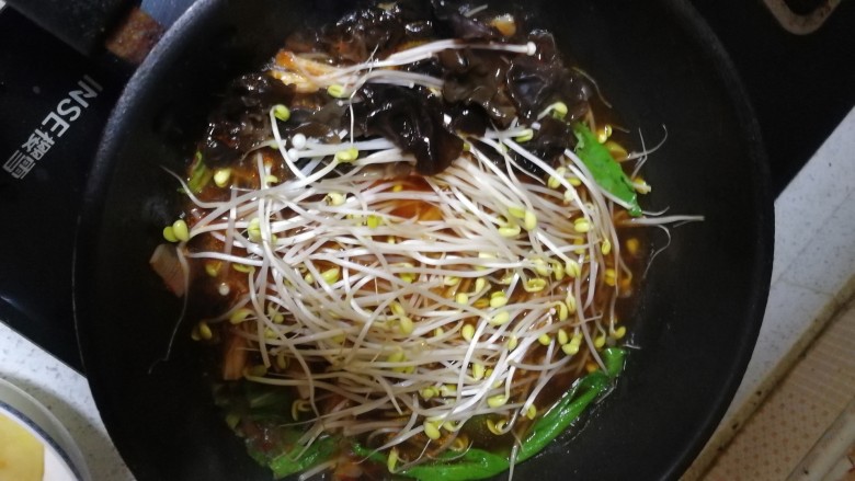 水煮肉片,锅烧开之后将配菜倒入锅中，盖好锅盖烧开即可，将锅里的配菜捞出放入碗中。