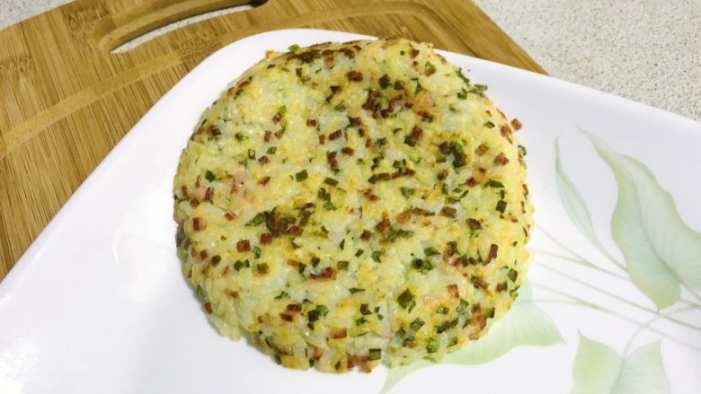 双层鸡肉米饭堡,煎好的米饭饼扣在盘子里,再煎另外一片。