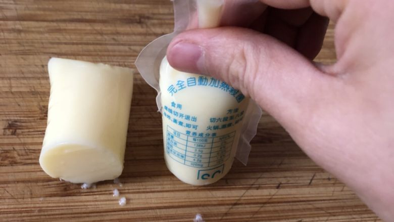 鲍汁豆腐,用手挤压袋子顶部,慢慢将豆腐挤出。