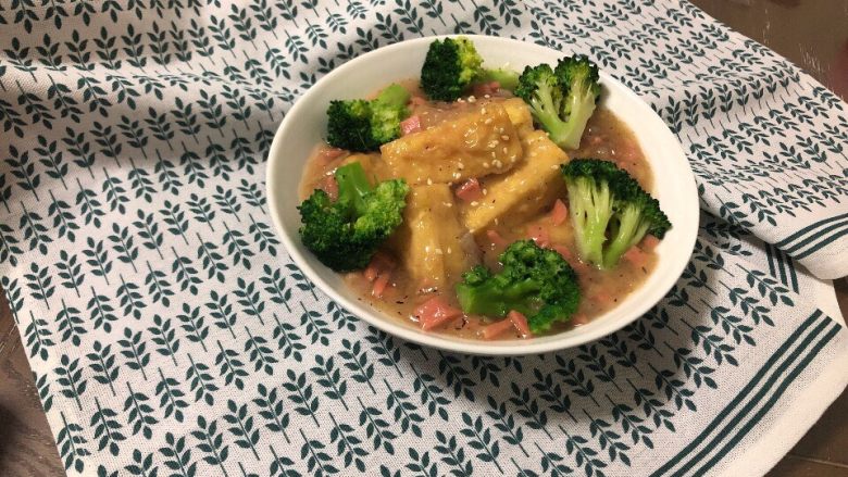 鲍汁豆腐,将操过水的西兰花摆盘,撒少许芝麻。