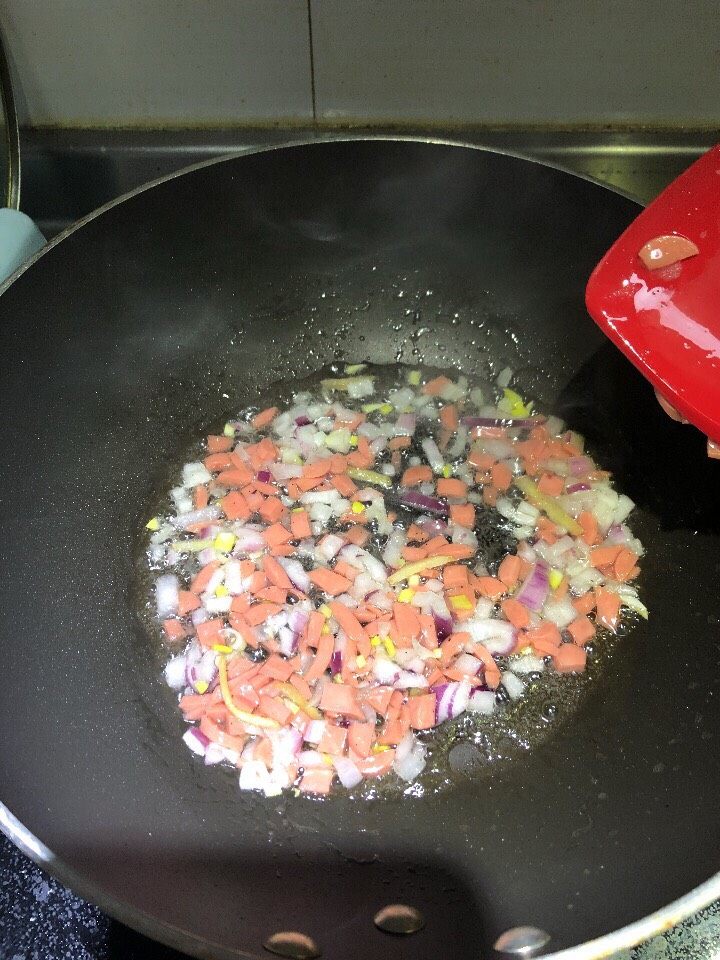 鲍汁豆腐,锅中放少许底油,依次放入姜丝、洋葱、火腿肠,煸香。