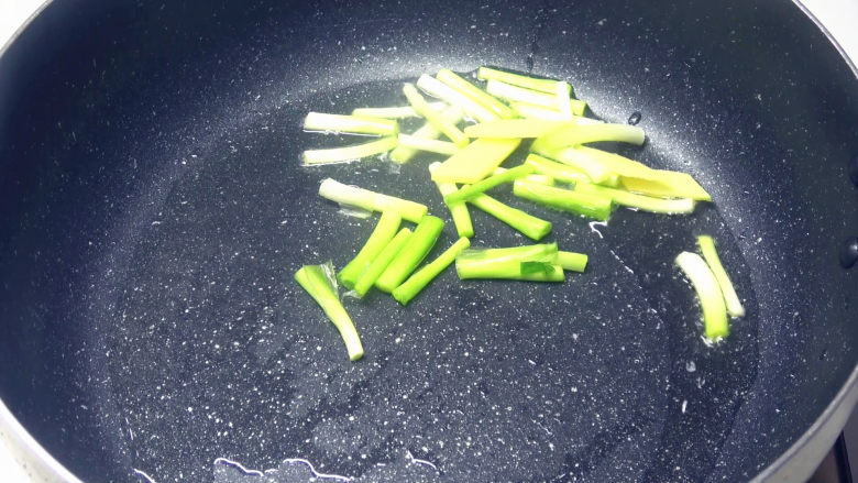 葱香腰花,起锅热油,下入姜片和葱白炒香