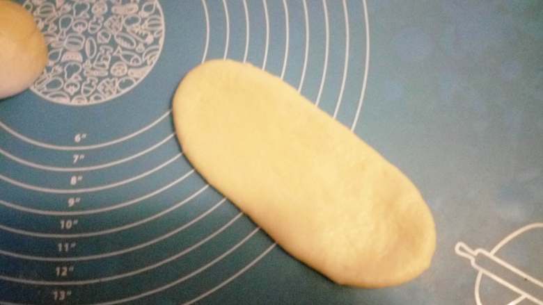火腿肠香葱面包 ,用擀面棒擀成牛舌状放入烤盘