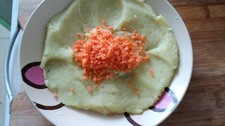 土豆藕饼,把切好的胡萝卜末放入土豆泥上
