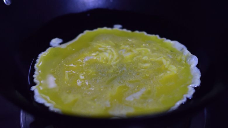 菠菜鸡蛋手擀面,油锅加热一汤匙油后转小火,倒入鸡蛋液。